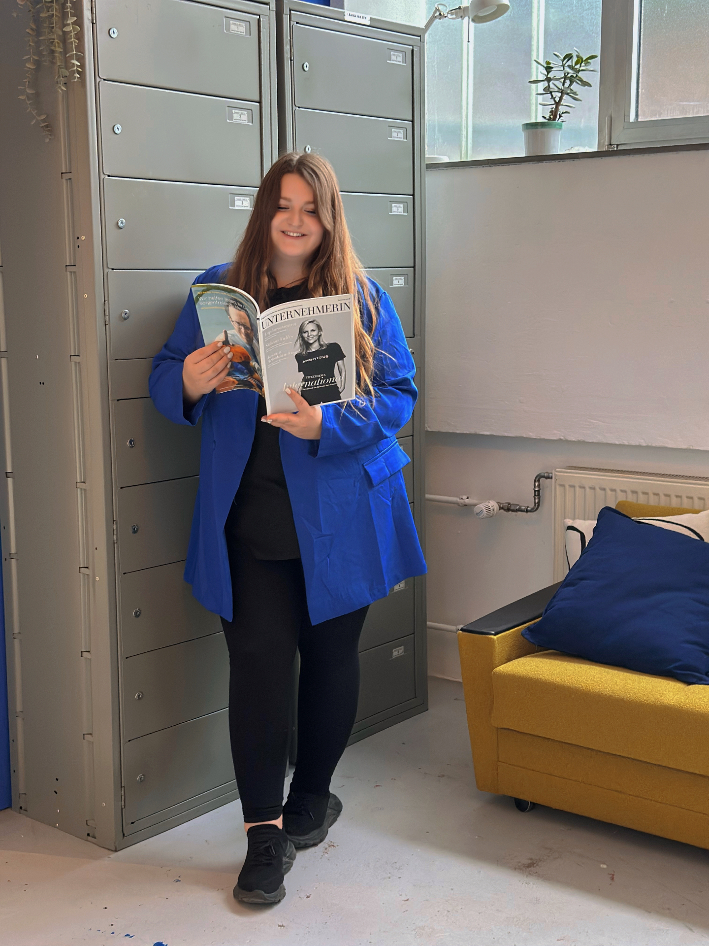 Stella Pollak im blauen Blazer mit dem Magazin „Unternehmerin“ in der Hand